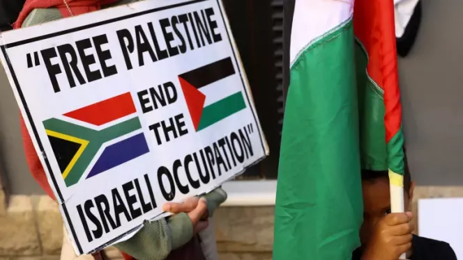 A boy holds a Palestinian flag during a demonstration to express support for the people of Palestine, in Cape Town, South Africa, October 9, 2023 [Esa Alexander/Reuters]