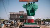 People stand next to the Independence Monument, depicting a hand holding a map of the country, in the city of Hargeisa, Somaliland, on September 19, 2021.  (Photo by EDUARDO SOTERAS/AFP via Getty Images)